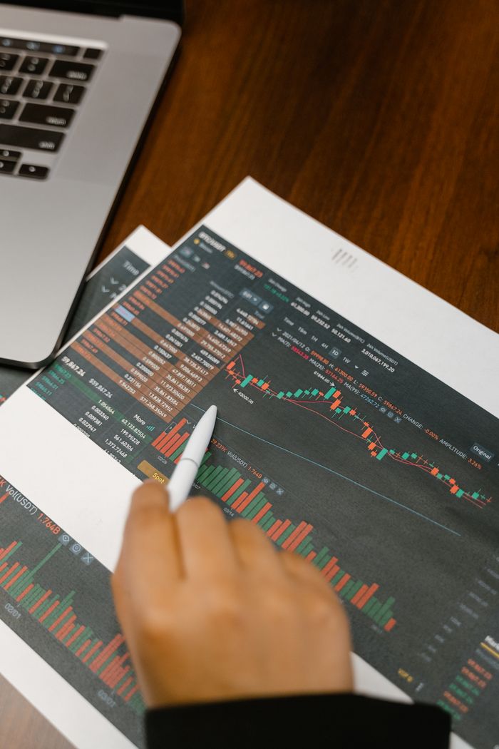 gallery-6 Close up of a person analyzing cryptocurrency graphs on printed charts.